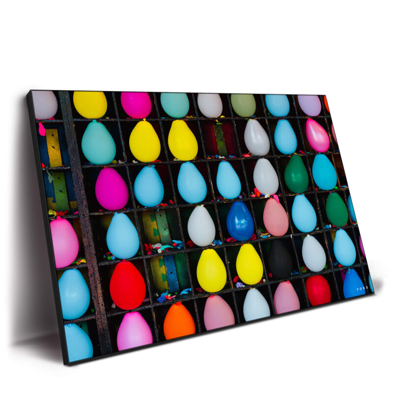 Colorful carnival balloons arranged in a game setup, showcasing a variety of bright colors against a blurred background.