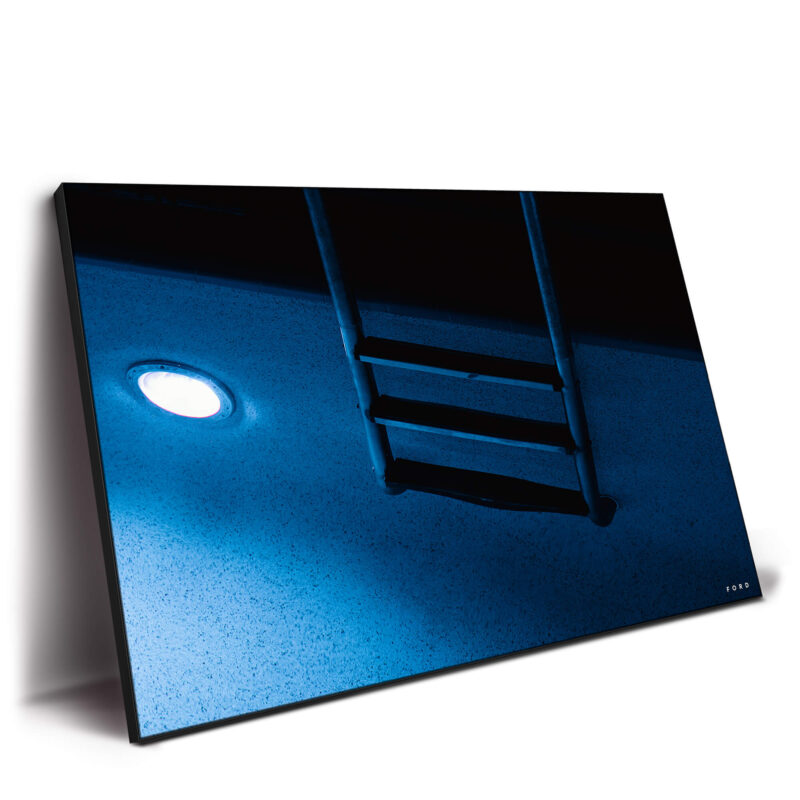 A blue pool at night, softly illuminated with reflections on the water.