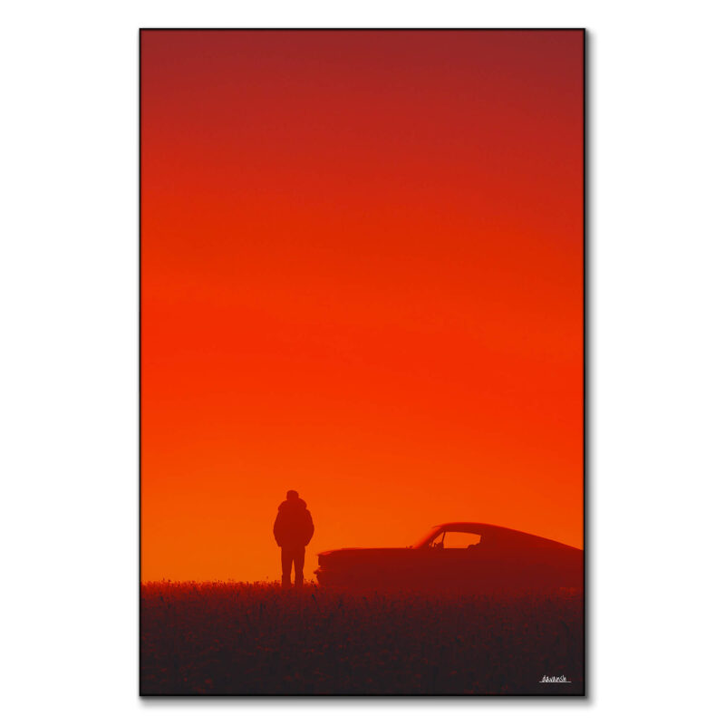 A silhouette of a man standing next to a vintage car against a red sunset backdrop.