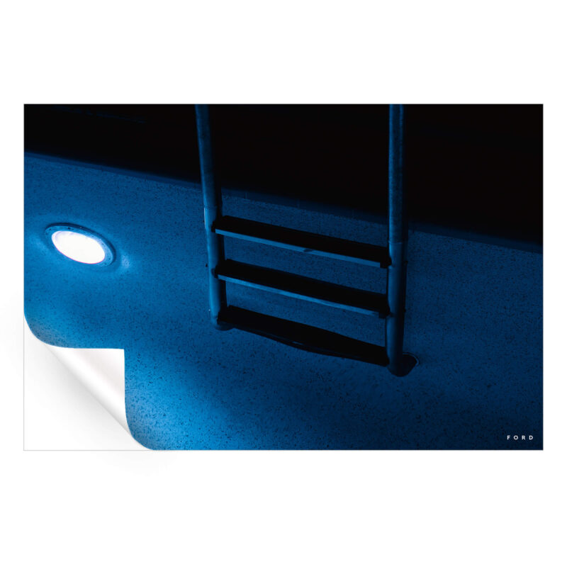 A blue pool at night, softly illuminated with reflections on the water.