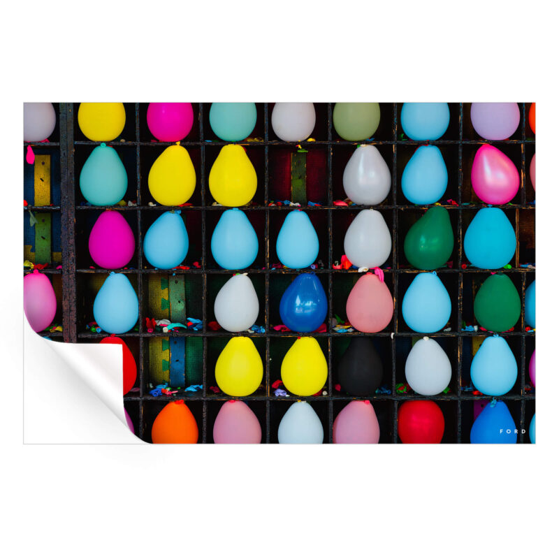 Colorful carnival balloons arranged in a game setup, showcasing a variety of bright colors against a blurred background.