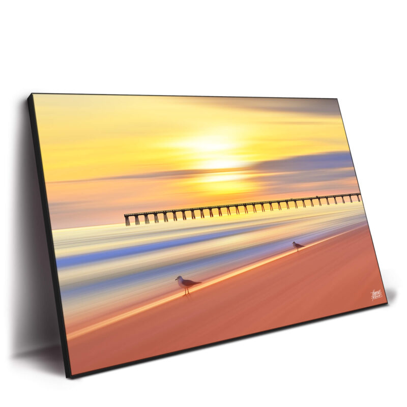 A sunset over the beach with seagulls flying, capturing a tranquil coastal scene with vibrant colors.