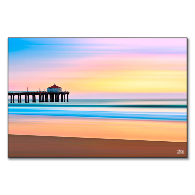 The Manhattan Beach Pier during sunset, with vibrant colors reflecting on the water, creating a serene beach atmosphere.