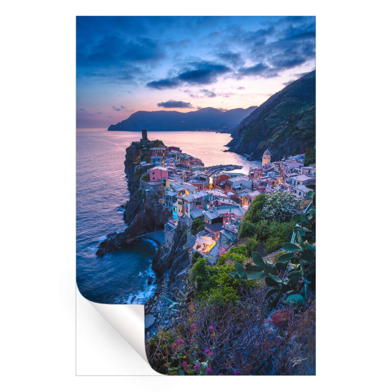 Vernazza village in Italy at sunset with colorful buildings by the sea.
